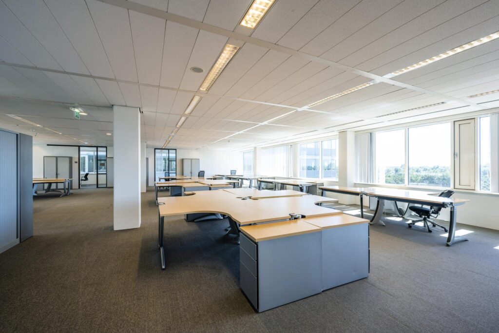 Ruim, licht en modern kantoorgebouw aan de Thomas R. Malthusstraat met meerdere werkplekken en grote ramen.